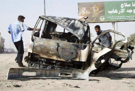 عراقيان يتفقدان شاحنة محترقة عقب هجوم بقنبلة في بغداد اول امس الخميس
